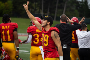 Gryphon football player celebrates on the sideline during homecoming game.