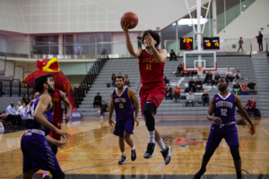 Trevor Hutton, #11, goes for a layup against the Western Mustangs on Nov 30.