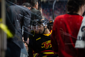 #25 Ryan Da Silva going over strategies with his team mate and a coach at the bench.
