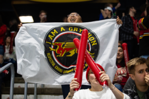 Student cheering while waving a flag at Frosty Mug 2020.