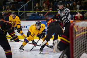 Player wait for the puck to drop during a face-off in Guelph's end of the rink.