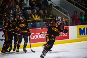 #92 Giordano Finoro skates towards center ice while he celebrates his goal.