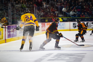 #92 Giordano Finoro sprays snow at Laurier player while quickly changing directions.