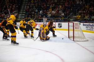 #28 Todd Winders skates past the net with 4 Laurier defensemen in tow after scoring a goal.